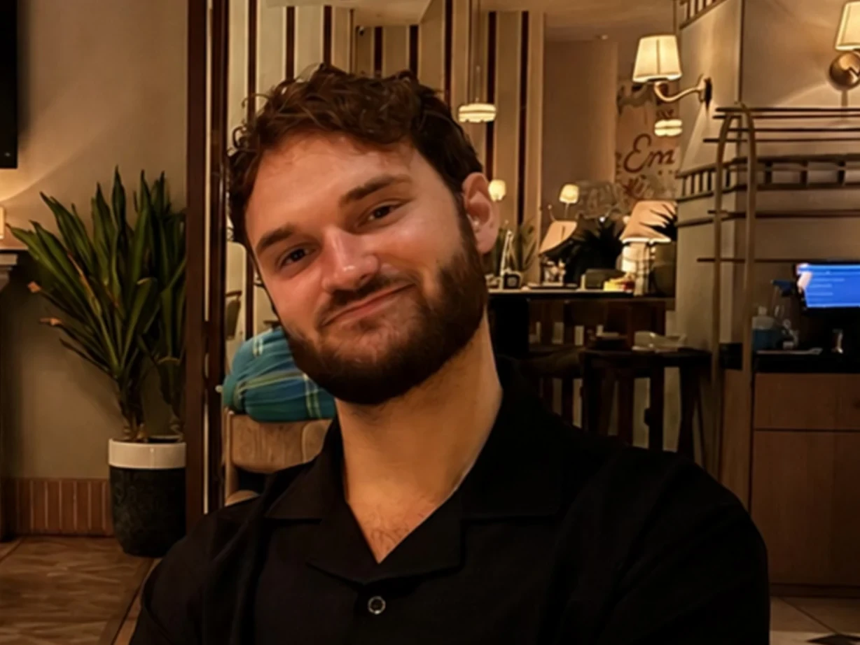 Portrait of a smiling man in a white T-shirt in a bright office