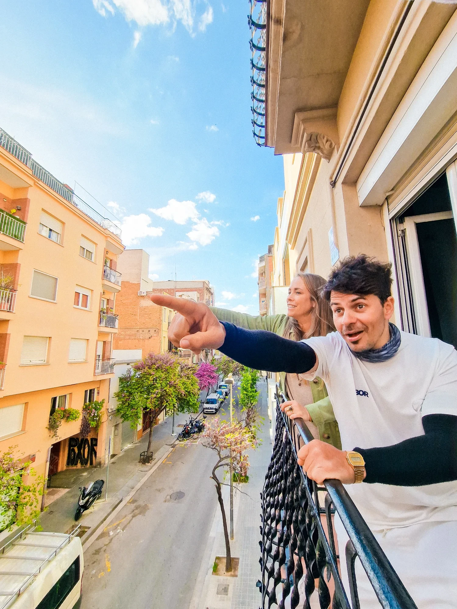 Ein Teammitglied zeigt vom Balkon über die Dächer