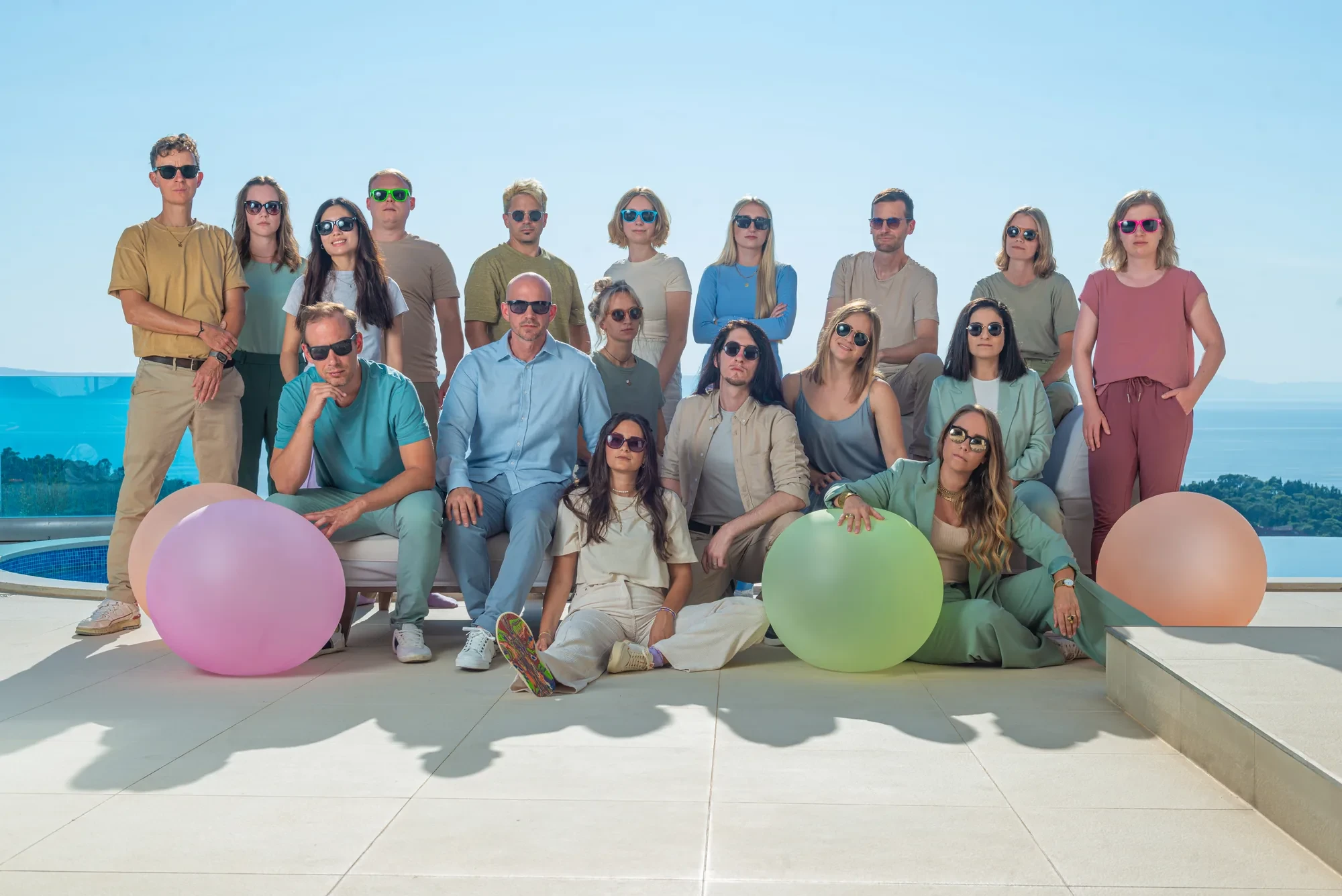 Das Team mit Luftballons auf einer Terrasse am Meer