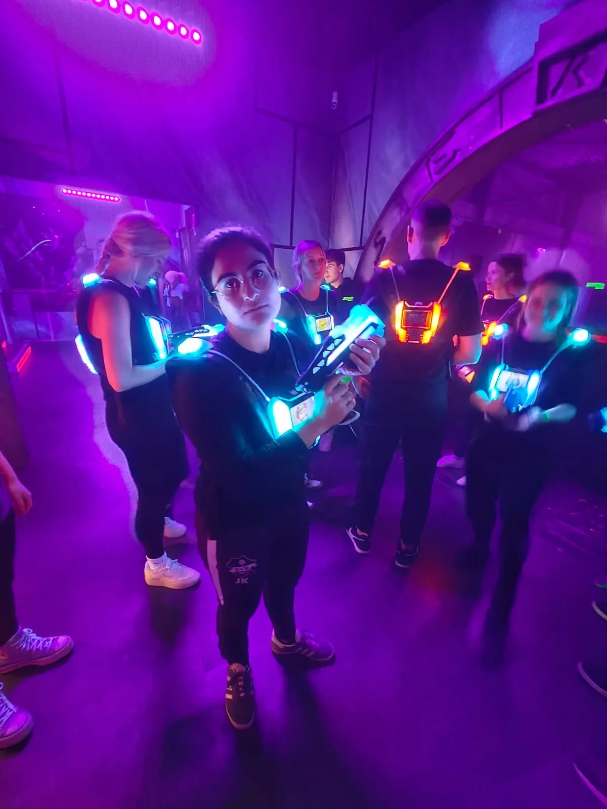 Teammitglieder in leuchtenden Westen beim Lasertag