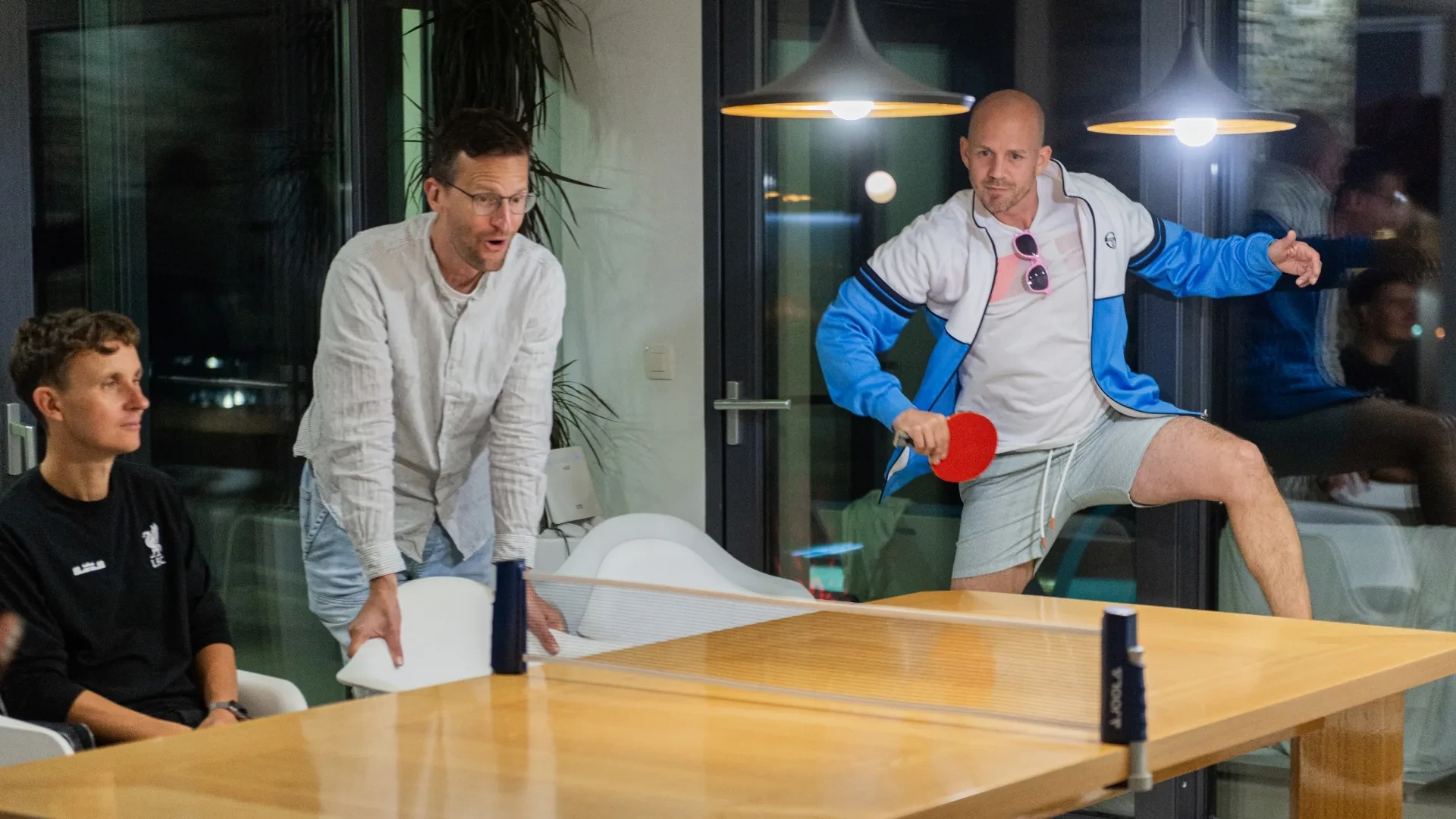 Zwei Teammitglieder beim Tischtennis im Büro