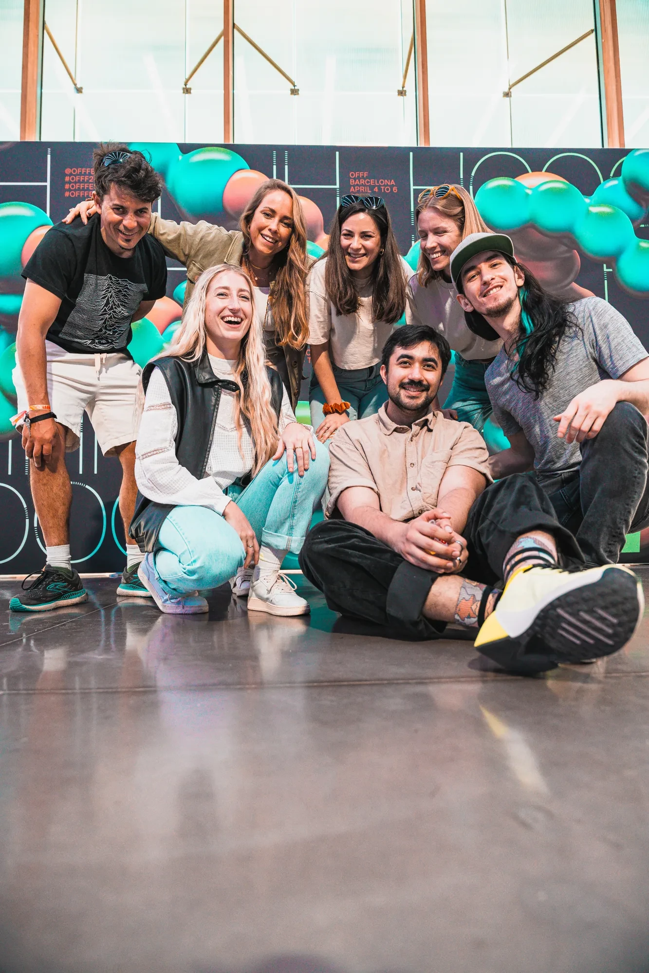 Das Team posiert vor einer Wand aus Luftballons