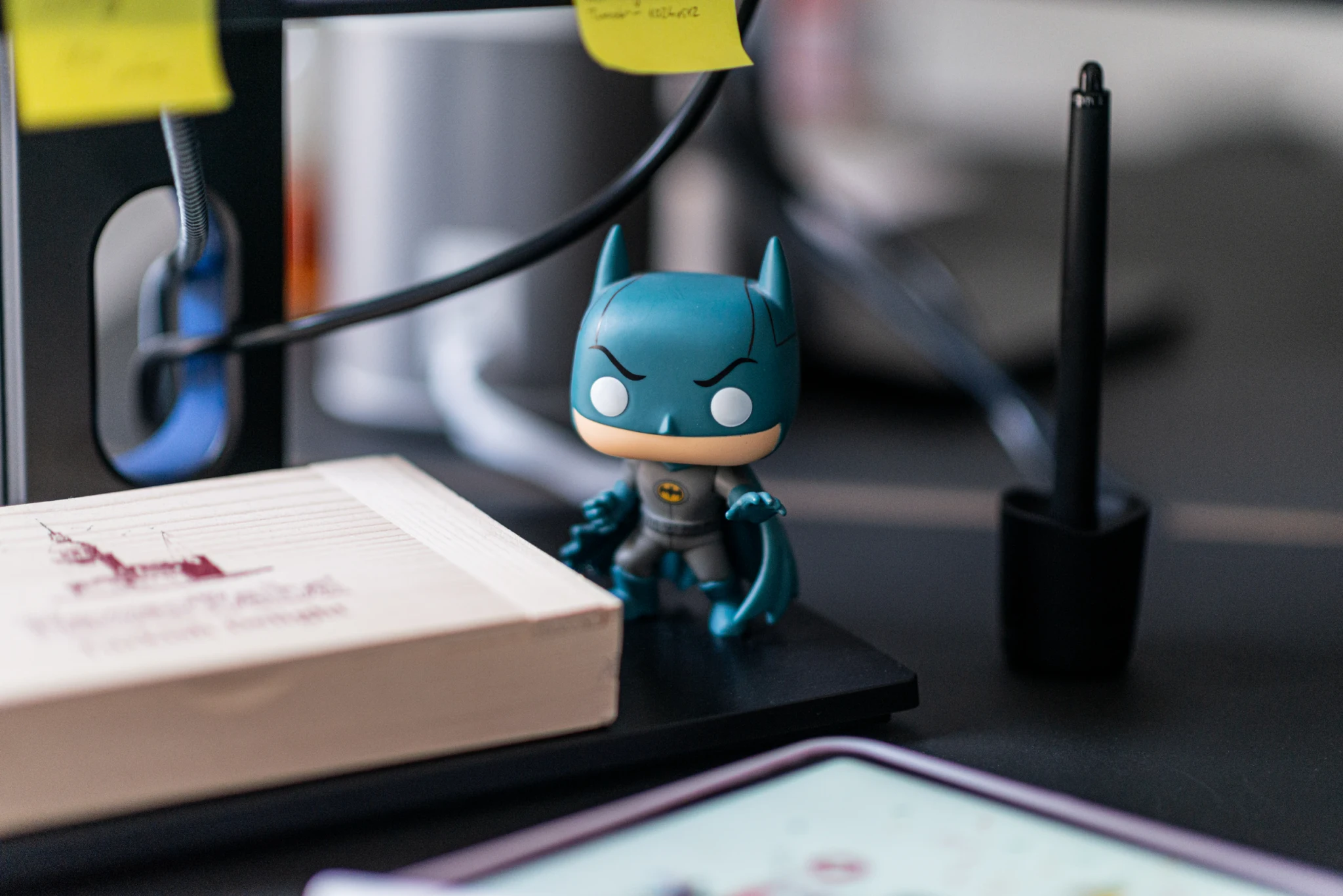 Eine Batman-Figur neben einem Zeichentablett auf einem Schreibtisch