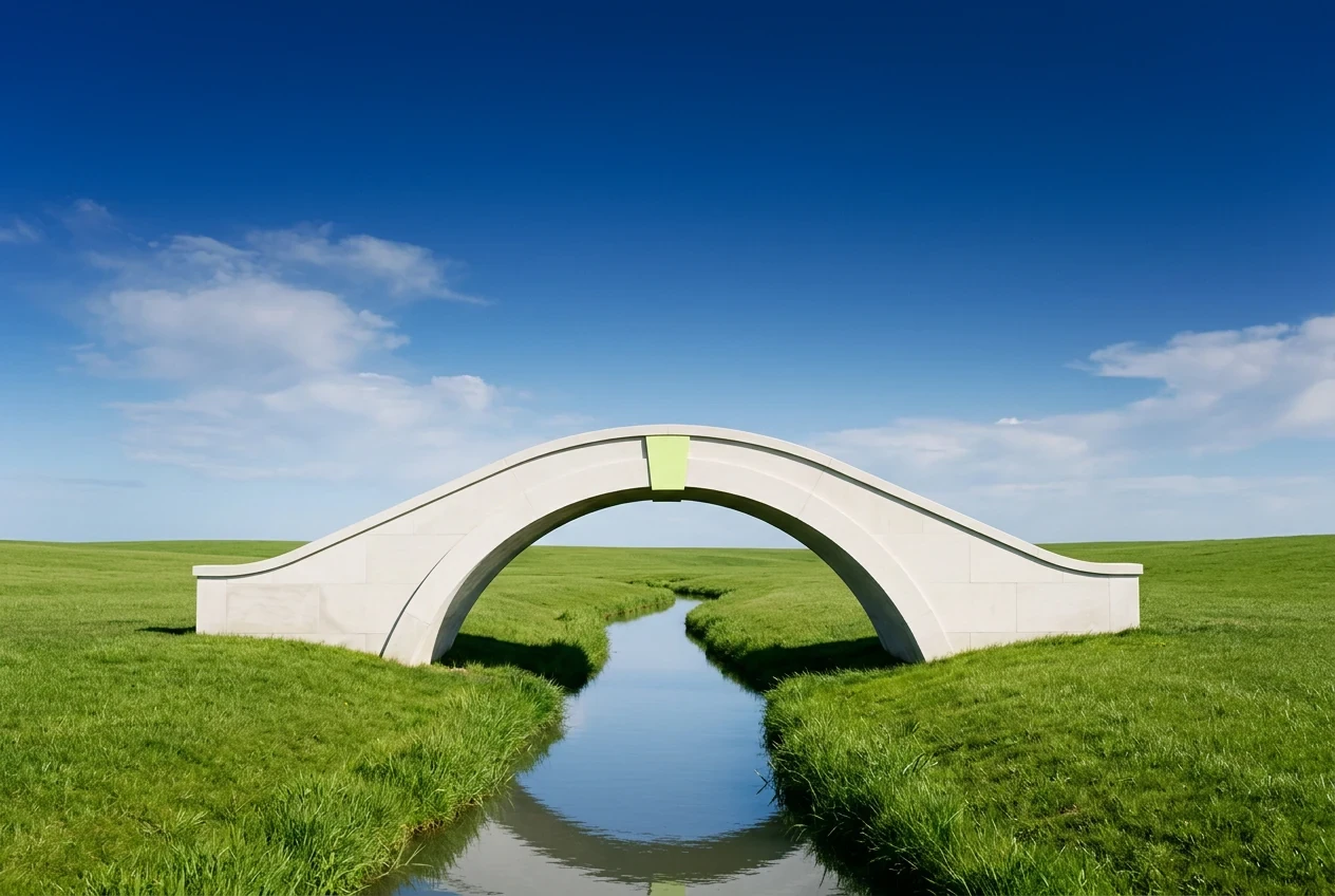 A white stone arch bridge with a lime keystone over a stream