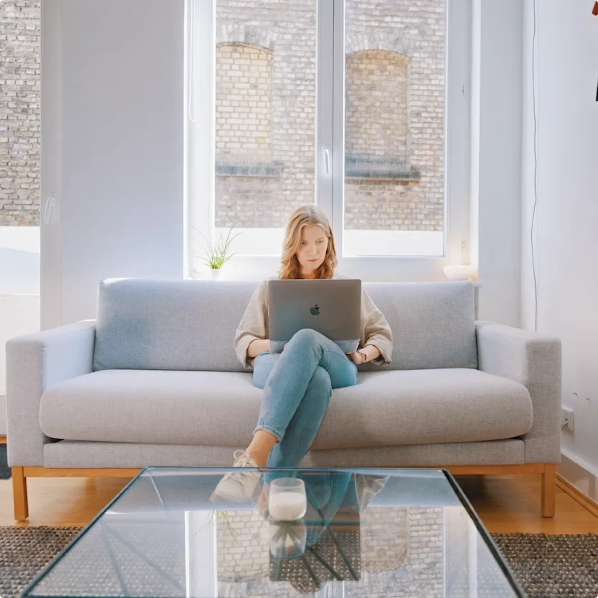 Eine Frau arbeitet im Lab-Büro mit dem Laptop auf dem Sofa